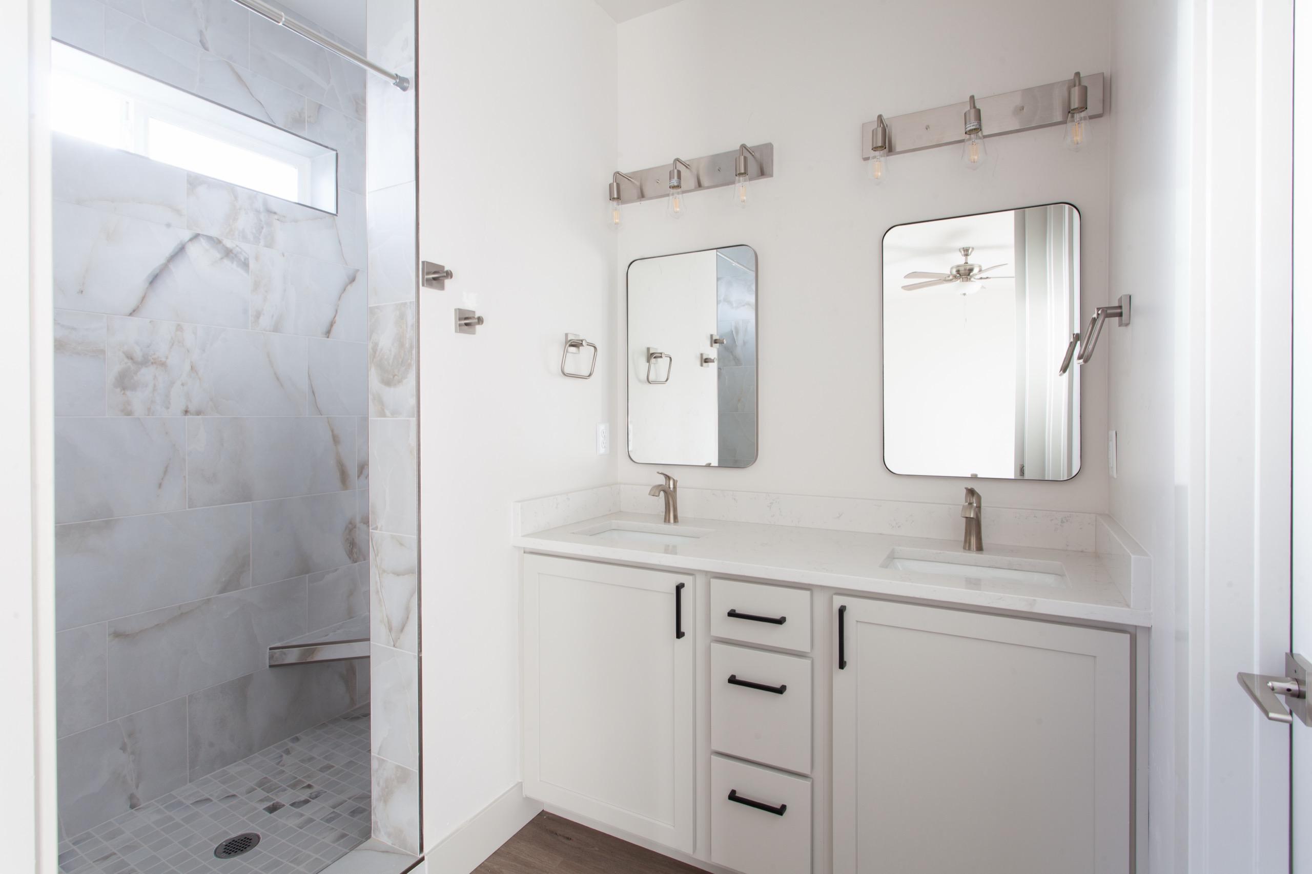 A calm, light-filled primary bathroom with a tiled walk-in shower in a Bear Homes home