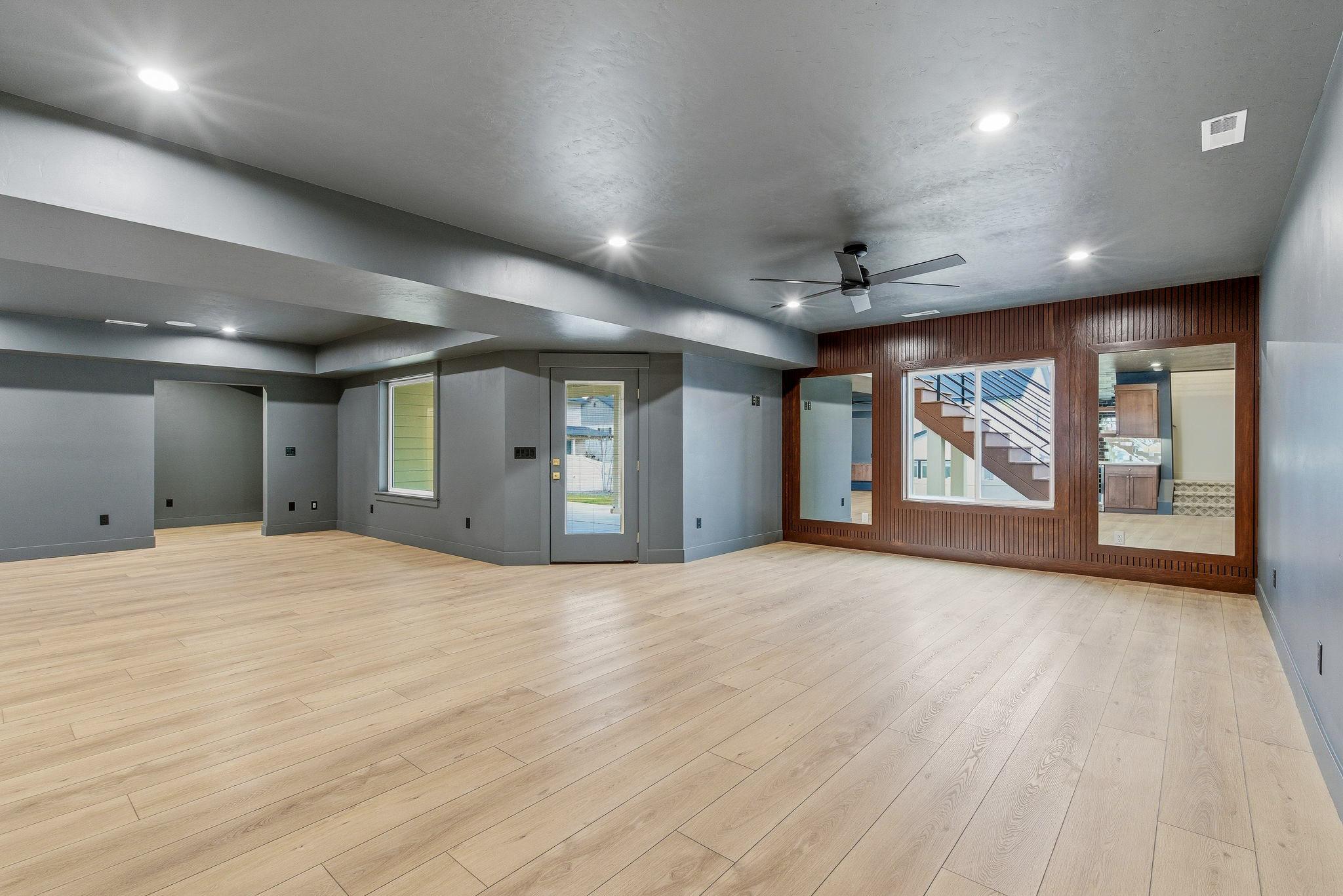 The finished basement rec room with a wood slat feature wall and interior windows