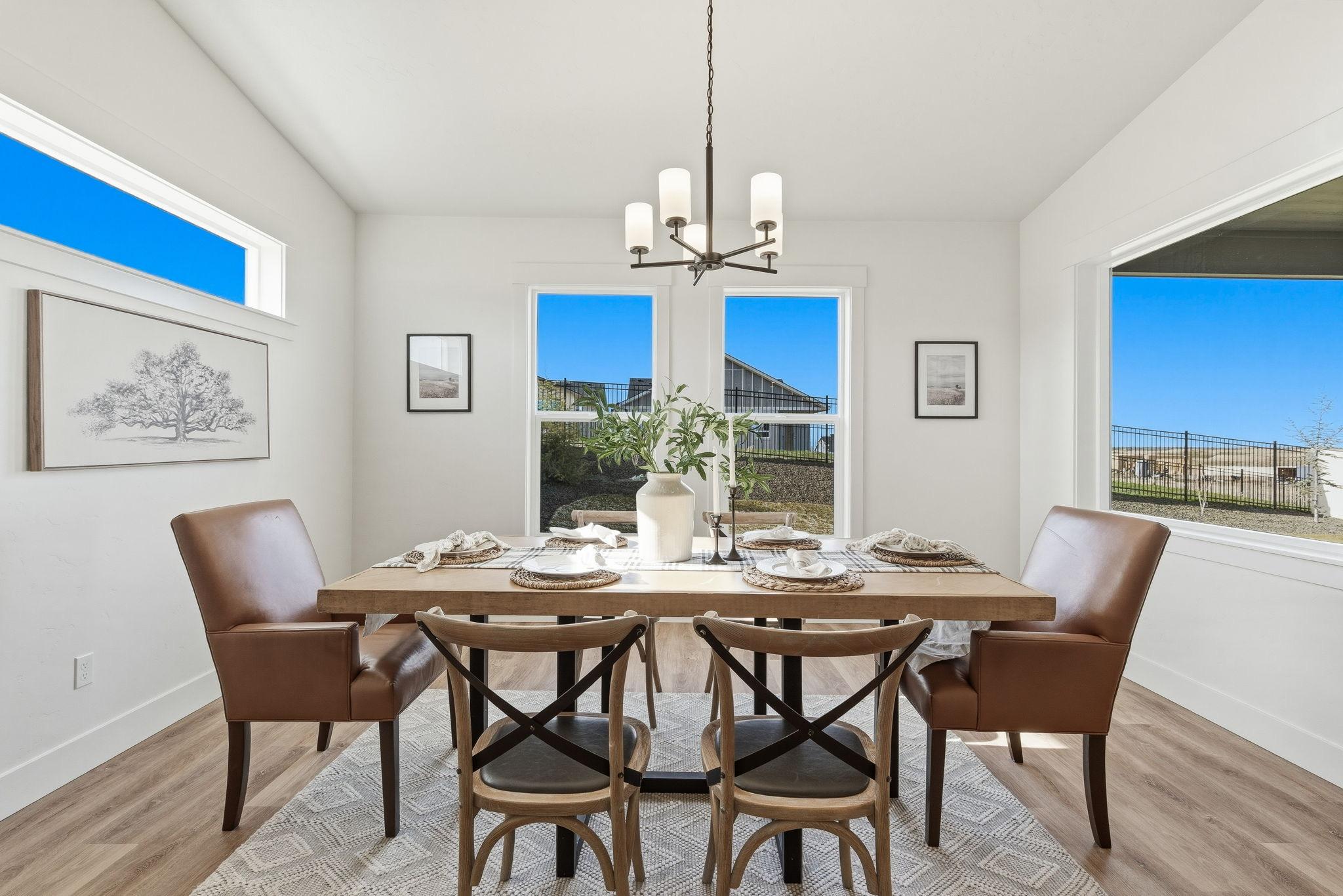 The dining area with a bronze chandelier and windows onto the back yard