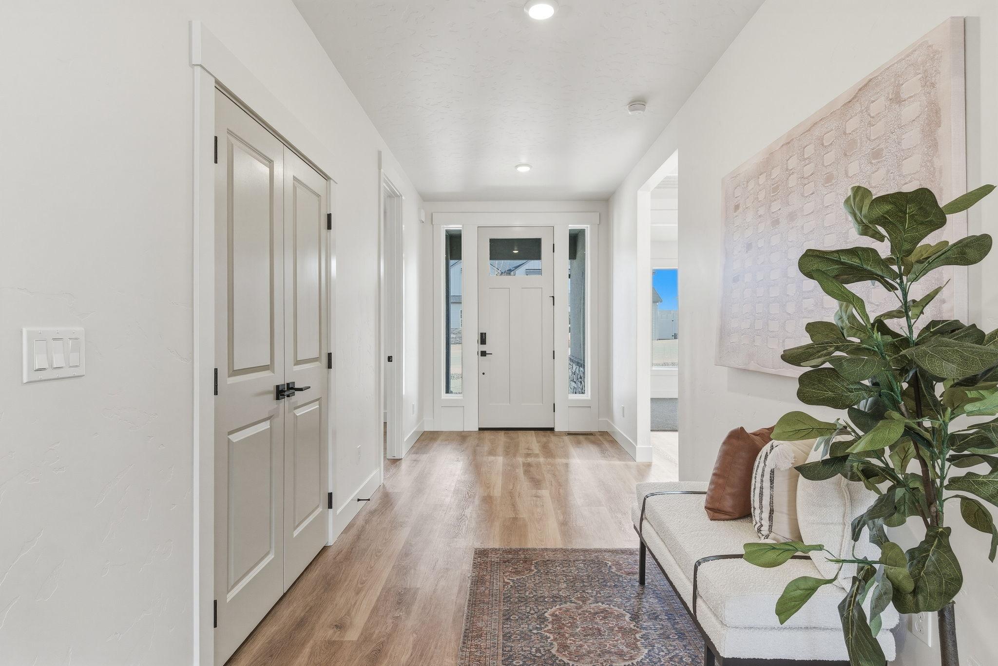 The entry hall with a craftsman front door, sidelights, and wide plank floors