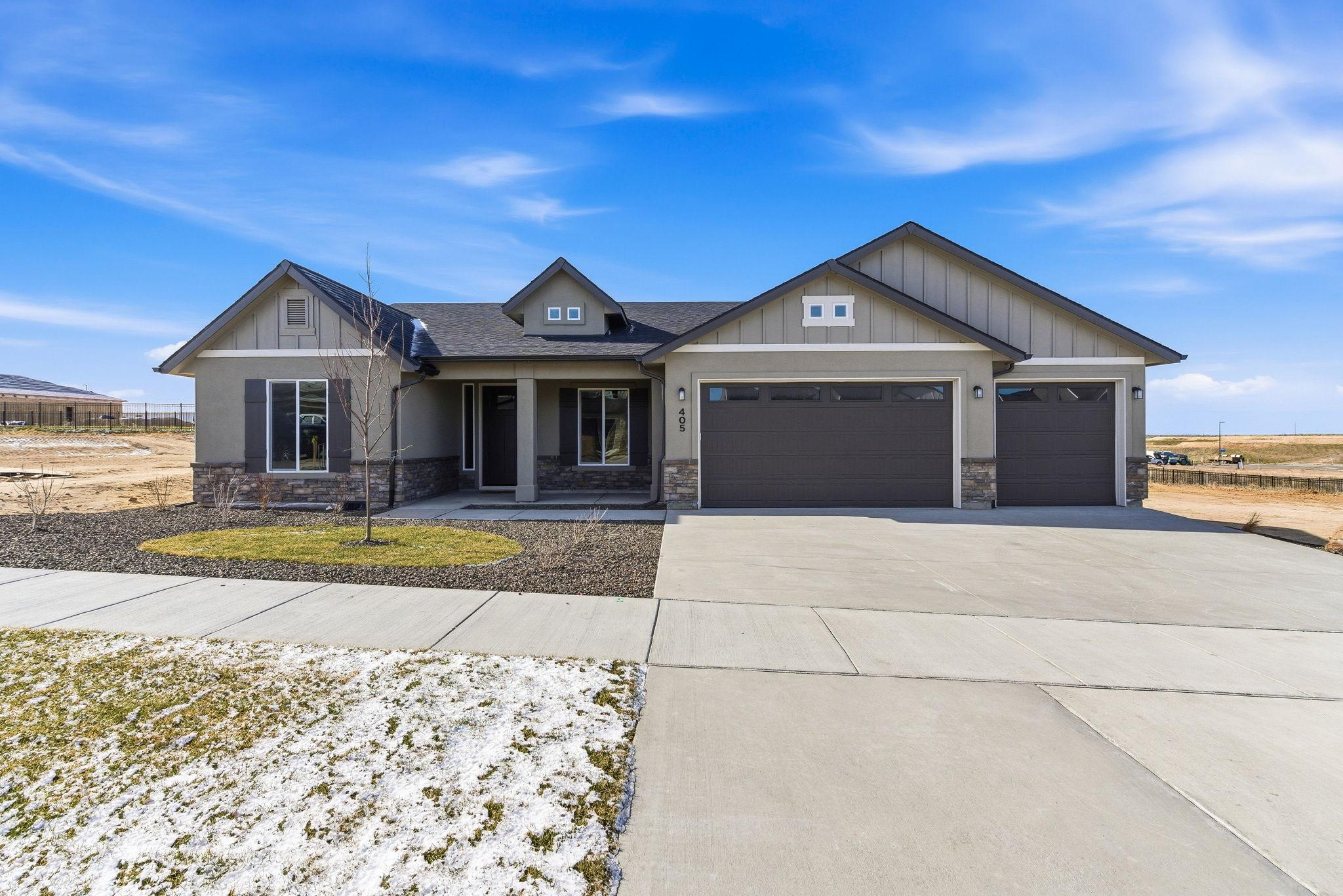 The front of 405 S Diesel Way in Boise: a single level craftsman with board and batten gables, stone wainscot, and a three car garage