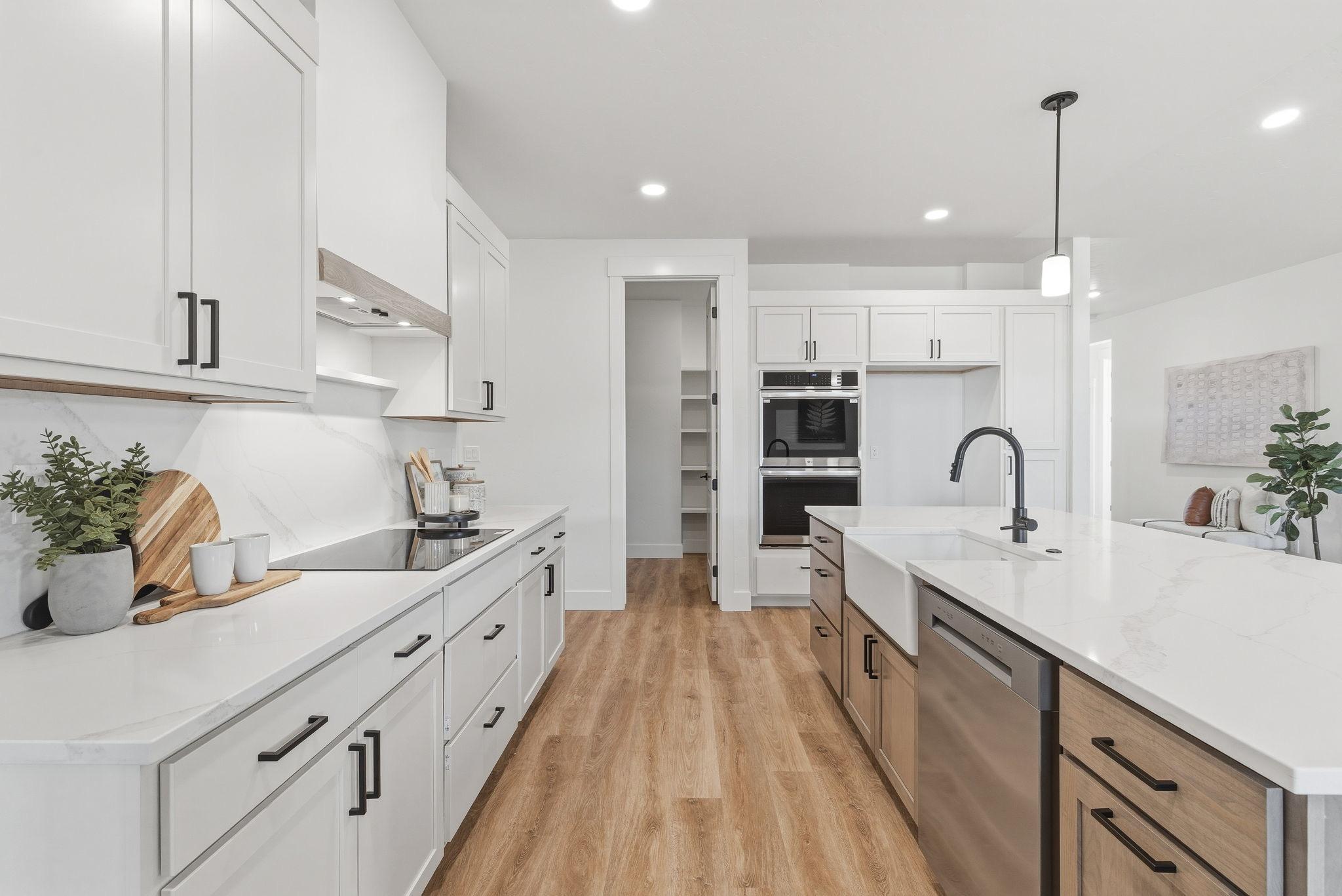 The kitchen: white shaker cabinetry, marble slab backsplash, double wall ovens, and a walk-in pantry