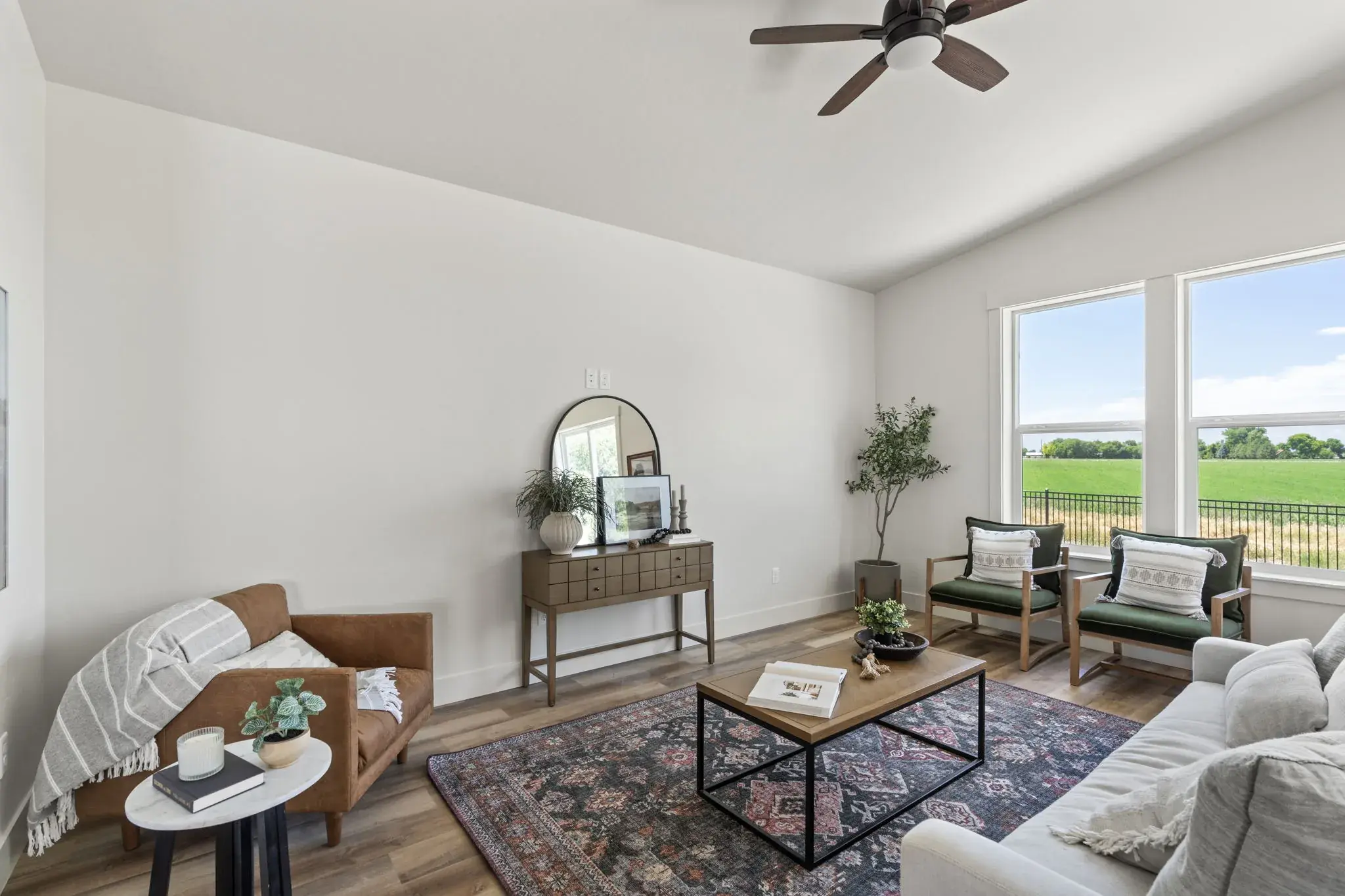 The living room at 509 Grand Harvest Avenue under a vaulted ceiling, with tall windows looking out over open farmland