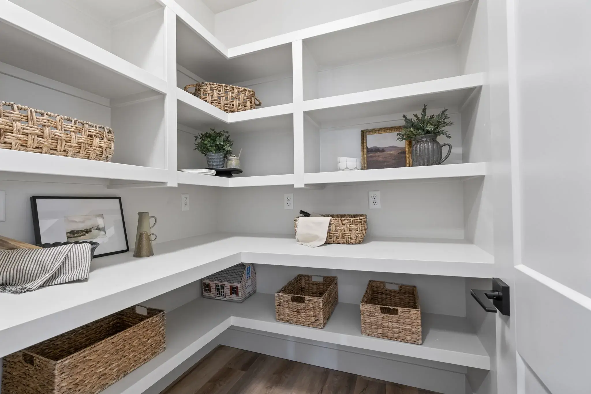 The walk-in pantry at 509 Grand Harvest Avenue, with white built-in shelving wrapping two walls above a counter