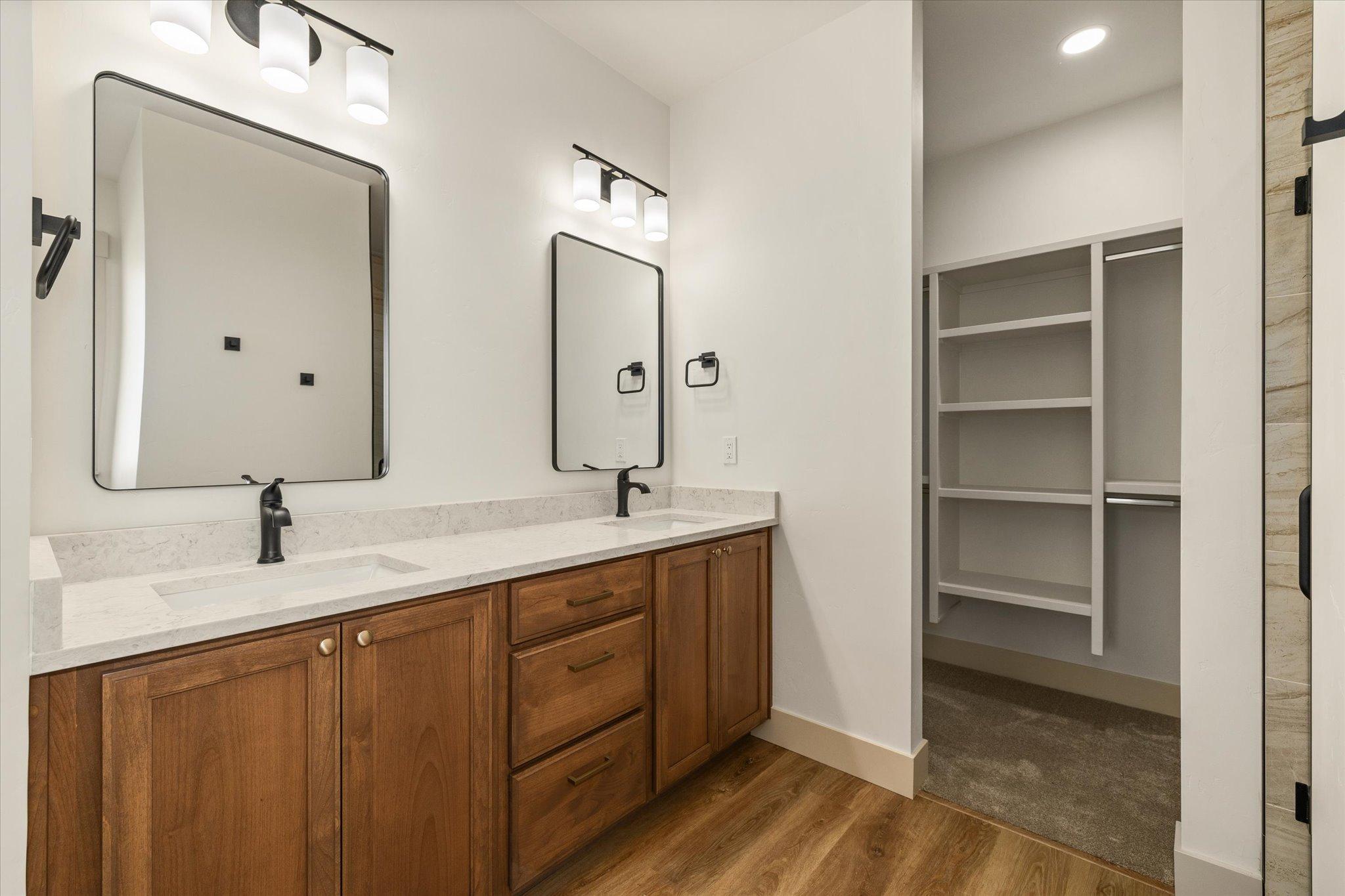 Primary bathroom double vanity beside the walk-in closet
