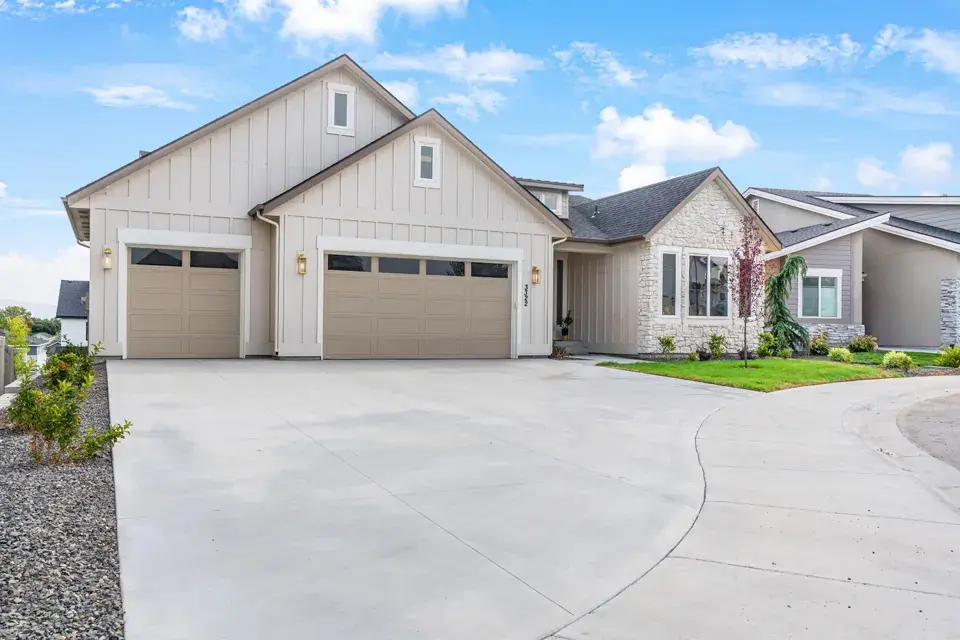 The front of White Oak & Timber in Meridian, Idaho: a single-level Bear Homes build with board and batten siding, a stone entry and a three car garage
