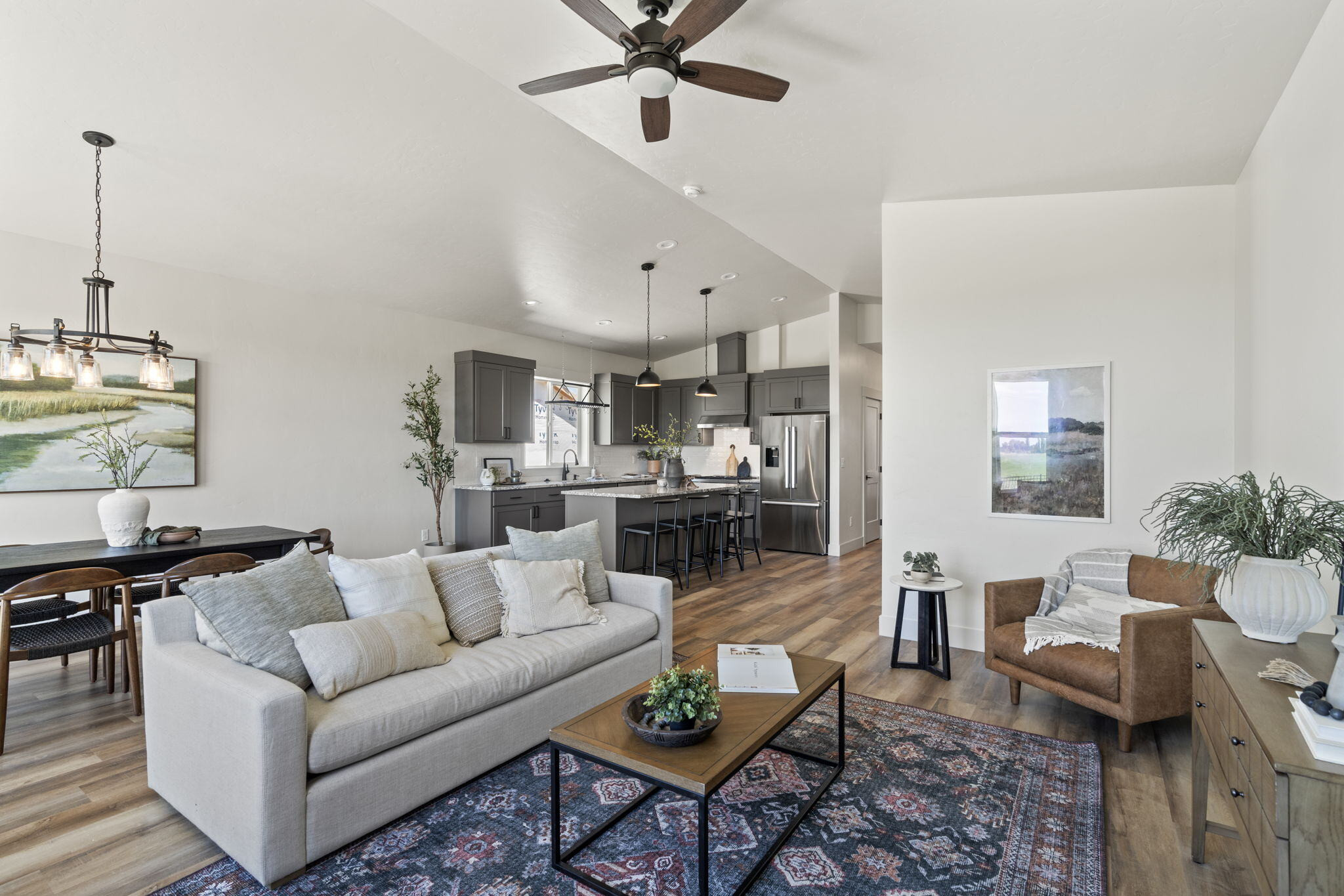 Vaulted open-plan great room with the dining area and kitchen beyond, in a Bear Homes build
