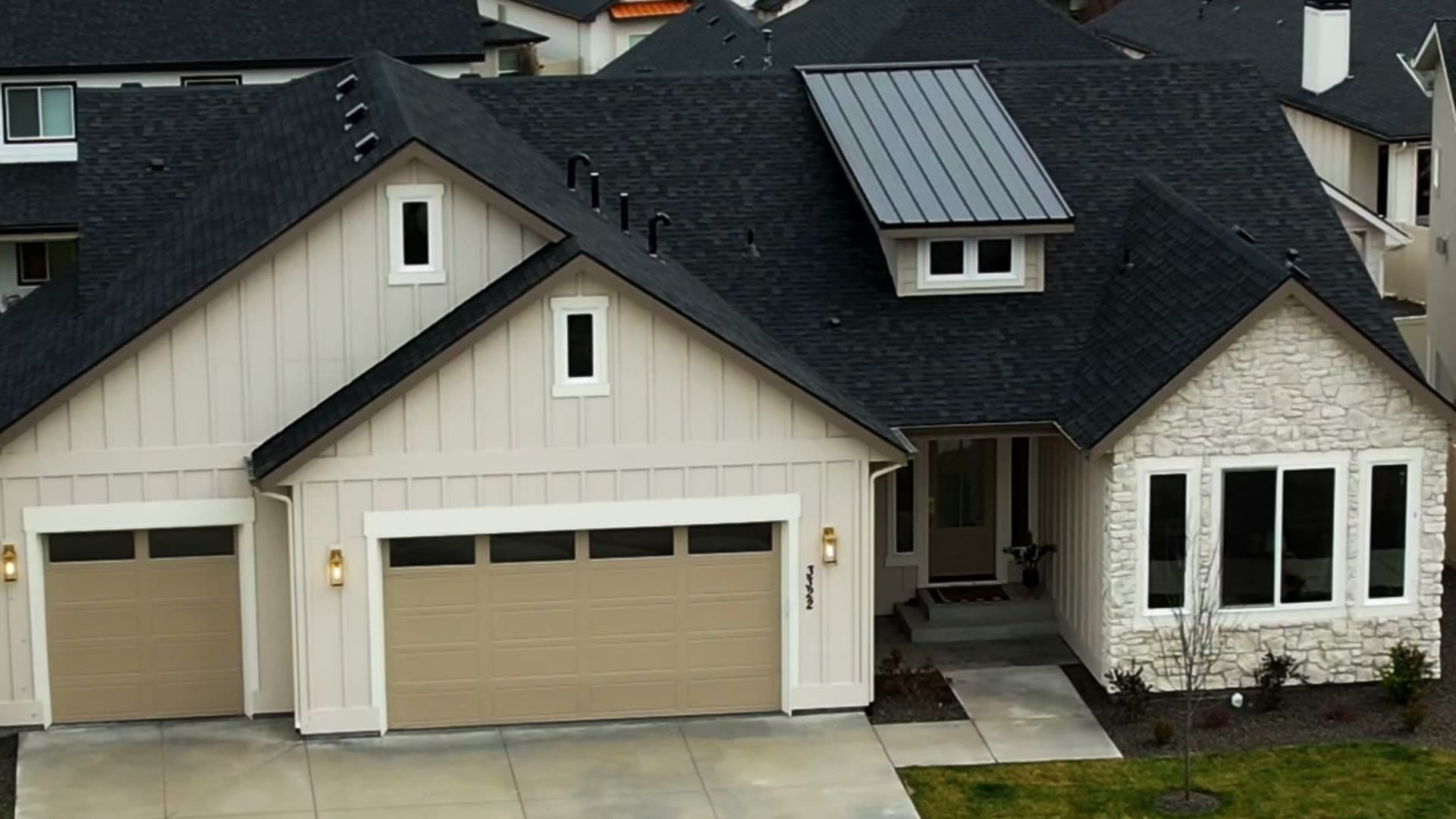 Aerial view of a Bear Homes build with board and batten siding and a stone-accented entry, from our home tour video
