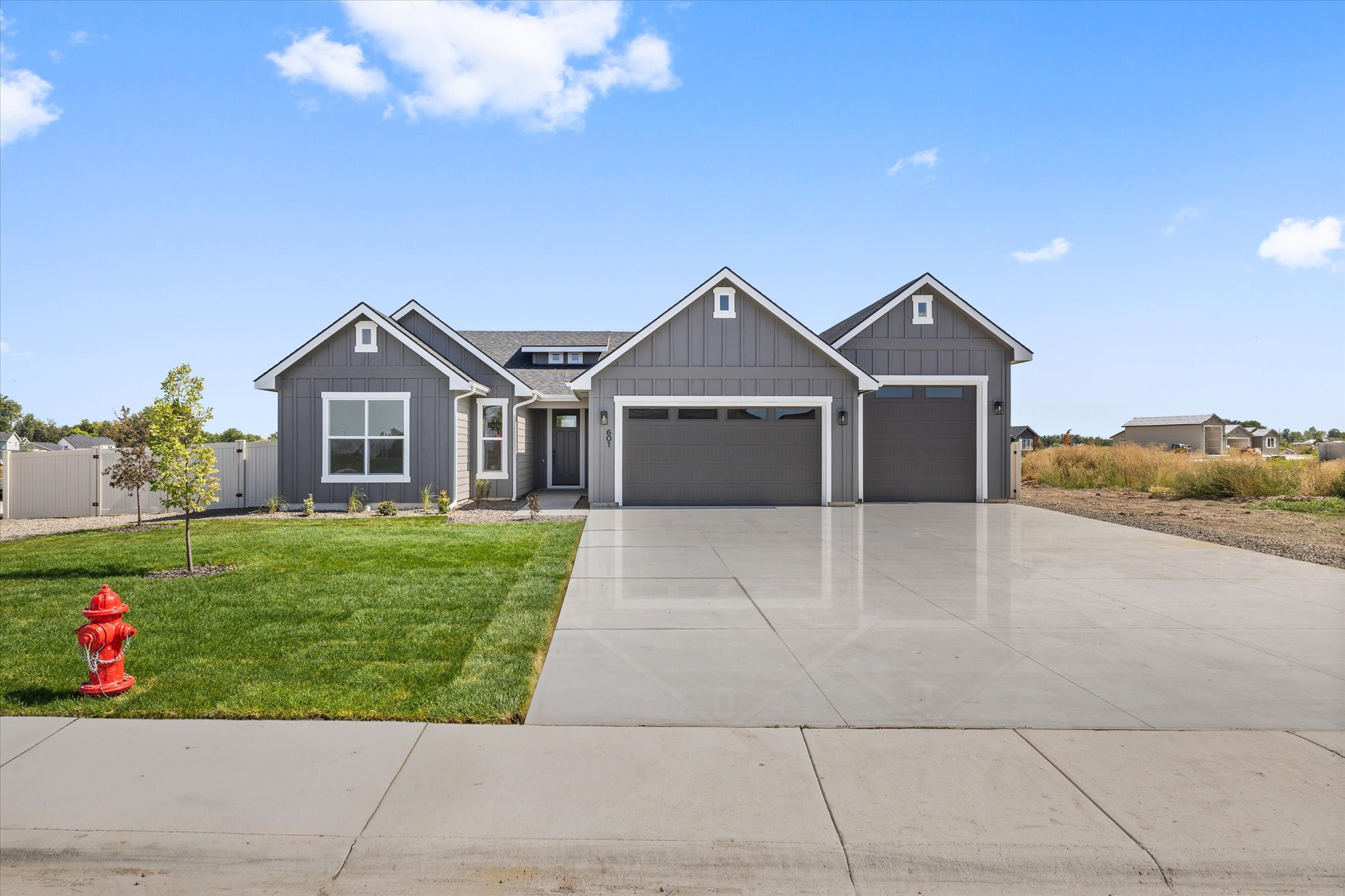 Front of 601 Grand Harvest Avenue, a gray single-level Payette plan home in Harvest Creek, New Plymouth, Idaho